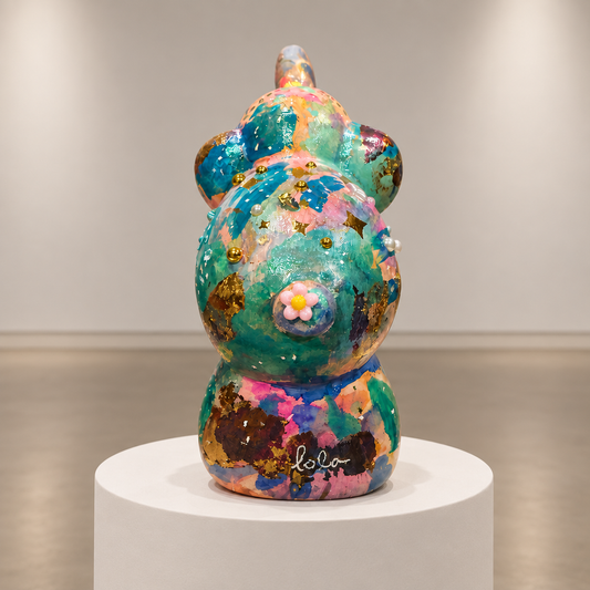Clover elephant sculpture on a circular pedestal, photographed in a soft neutral gallery